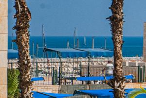 a view of the ocean from a resort with palm trees at חופשה בממלכה in Ashkelon
