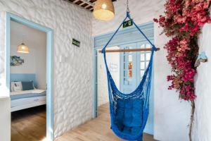 a blue hammock in a room with a bedroom at Pousada Vila DuJu in Porto De Galinhas