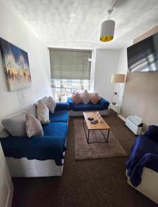 a living room with a blue couch and a table at Boho Bliss in Swansea