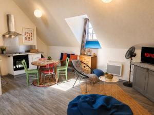 a living room with a table and chairs at Le Nid Dolois in Dole