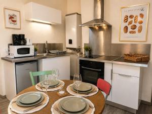 a kitchen with a table with plates and wine glasses at Le Nid Dolois in Dole +8 photos