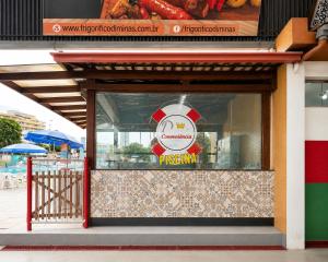a restaurant window with a pizza sign on it at Apê 201 - Vem Aí in Governador Valadares