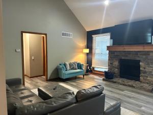 a living room with a leather couch and a fireplace at The Welcome Home in Topeka