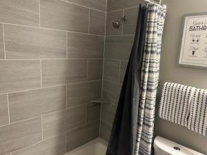 a bathroom with a shower with a shower curtain at The Welcome Home in Topeka +28 photos