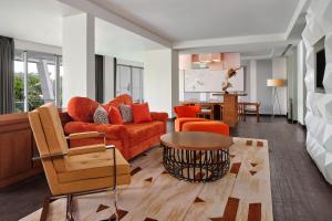 a living room with orange furniture and a table at Le Meridien Bali Jimbaran in Jimbaran