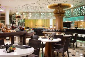 a restaurant with tables and chairs and a pillar at Le Meridien Bali Jimbaran in Jimbaran