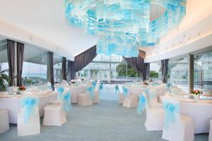 a banquet hall with white tables and chairs and a chandelier at Le Meridien Bali Jimbaran in Jimbaran +72 photos