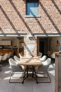 a table and chairs in front of a brick wall at Boutique Hotel Het Zoete Zijn in Borgloon