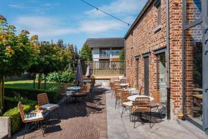 a patio with tables and chairs next to a brick building at Boutique Hotel Het Zoete Zijn in Borgloon