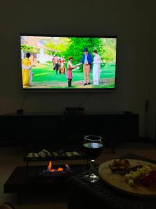 a flat screen tv hanging on a wall with people playing golf at Areal in Areal