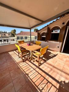 a wooden table and chairs on a patio at Tproject in Preveza