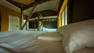 a large white bed in a room with a bunk bed at Camp & Hostel Maltakva in Poti