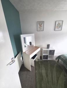 a bedroom with a desk with a bed and a mirror at Horizon Hideaway in Swansea