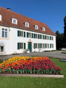 a large white building with flowers in front of it at Hotel Pension Haus Stork in Holzhausen