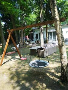 a swing set in front of a house at Leśna Przystań in Pojezierze