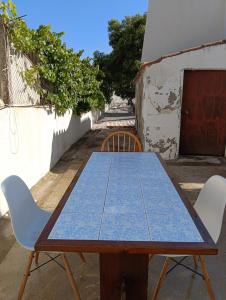 a wooden table with two chairs and a blue table and chairs at Pousada Mar de Calma in Montemor-o-Novo