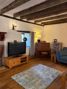 a living room with a flat screen tv and a couch at Woolladon Hall in Meeth