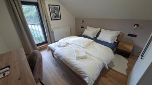 a bedroom with a large bed with white sheets and pillows at Kuća za odmor Vrata Papuka in Pakrac