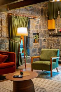 a living room with two chairs and a table at Dolana Wadi Taş Evleri in Pirinçlik
