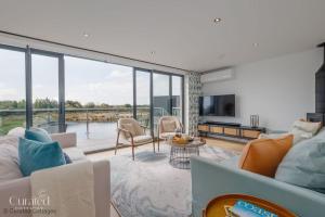 a living room with a couch and a large window at Knighton in Warmwell