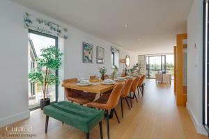 a dining room with a long table and chairs at Knighton in Warmwell
