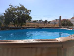 a large blue swimming pool with a fence around it at Pousada Mar de Calma in Montemor-o-Novo