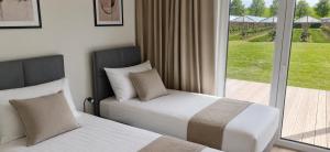 two beds in a hotel room with a balcony at Ferienhaus Elbdeichblick 1 in Haselau