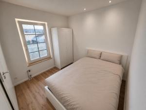 a small white bedroom with a bed and a window at MeerZeit in Kappeln