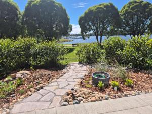 a garden with a stone walkway next to a body of water at Villa Kaisla in Raahe