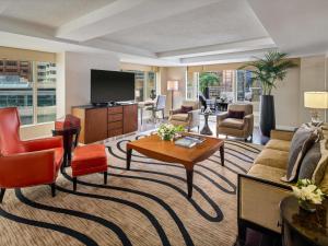 a living room with a couch and a tv at Fairmont Waterfront in Vancouver