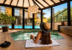 a woman in a hat sitting next to a swimming pool at Hotel Casa Encantada in Penedo