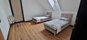 a room with two beds and a chair in it at Dom Na Chwilę in Brzozowa +22 photos