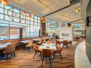 a restaurant with tables and chairs and large windows at Fairmont Waterfront in Vancouver