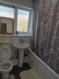 a bathroom with a toilet and a sink and a window at Private Room wigan in Atherton