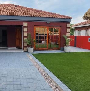 a house with a green lawn in front of it at Royal Inn Boutique Lodge in Gaborone
