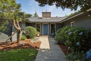 a house with a blue door and some bushes at Baskets, Brews & Views: Epic Wenatchee Escape! in Wenatchee
