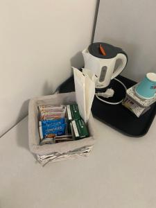 Ein Behälter mit Büchern und eine Teekanne auf einem Tisch in der Unterkunft Scalea Sunrise in Scalea