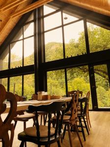 a dining room with a table and chairs and windows at Cabana Crang in Dobra