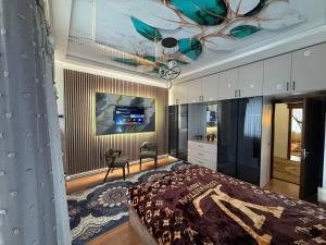 a bedroom with a bed and a tv on the ceiling at Madigul in Andijan
