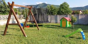 a swing set and a playground in a yard at Vikendica Castanea Banja Ždrelo in Petrovac na Mlavi