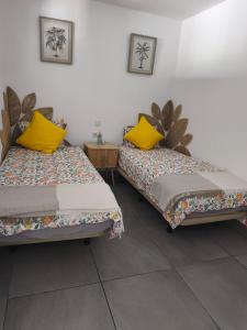 two beds sitting next to each other in a room at Central Apartment 4P Playa Chica Beach 2min WIFI in Puerto del Carmen