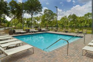 a swimming pool with lounge chairs and tables at Element by Marriott Bainbridge Riverfront in Bainbridge