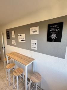 a table and stools with signs on a wall at Business & Relax Suite - Panorama - 2 Schlafzimmer - Parkplatz in Sindelfingen