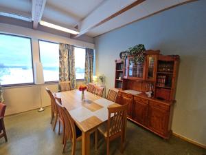 a dining room with a wooden table and chairs at Solheim Guesthouse Andøy in Dverberg
