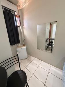 a room with a mirror and a chair and a table at Hospedaria Maranhense in São Luís