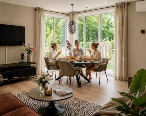 a group of people sitting around a table in a living room at Chalet FoRest Veluwe with private hottub & incl wood! in Putten