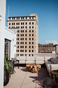 a rooftop patio with couches and a dog laying on the ground at The Hotel Monroe, Tapestry Collection By Hilton in Monroe