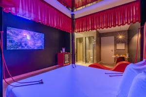 a room with red curtains and a tv on a wall at Dreams Motel (Adult Only) in Fortaleza
