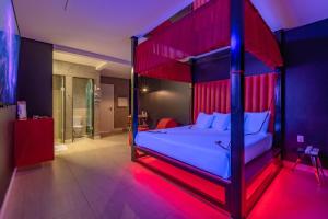 a bedroom with a bed with a blue and red canopy at Dreams Motel (Adult Only) in Fortaleza +32 photos