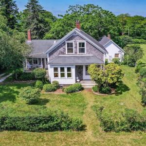 a white house with a yard with bushes and trees at Westport Point Farmhouse in Westport Point